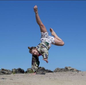 Katherine dances in her spare time Dancer balancing on one hand in an outdoor setting
